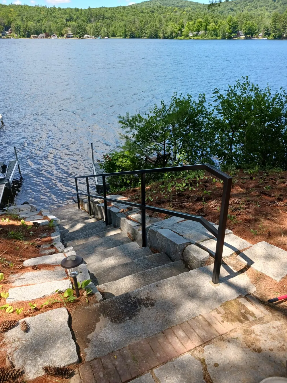 Handrail on stone steps leading to a lake