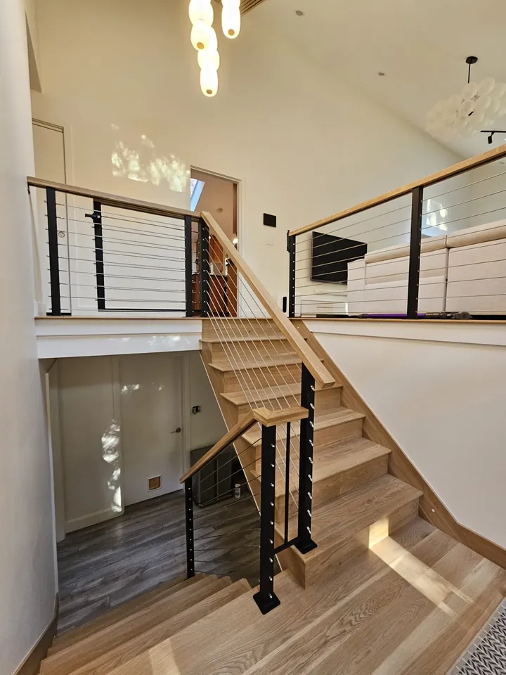 Interior railing with wood handrail on an open staircase